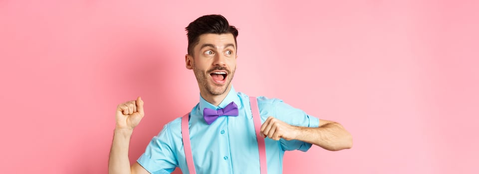 Portrait of funny young guy hurry up and running, looking aside with excited face, rushing to get promo offer, standing over pink background photo
