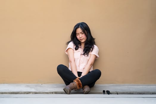 Asian woman is sitting alone on the rooftop of building with tried and disappointed mood and tone in that day. photo