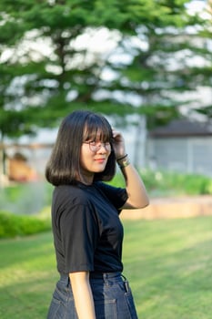 Portrait of the Asian glassese Thai woman is standing in the garden in the morning. photo