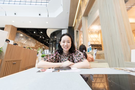 The Asian woman is sitting in front of electric stove that build in the Table in Shabu Restaurant. She waits for her menu from the waitress. photo