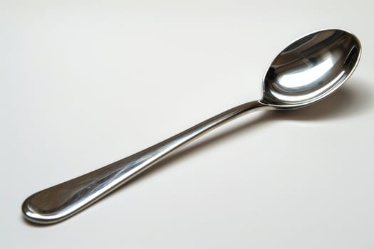 A silver metal spoon isolated on a white background. photo