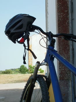 Mountain bike leaning against a wall, with helmet hanging on the handlebar. Perfect for outdoor adventure, cycling, and sports themes. Ideal for stock photography use. photo