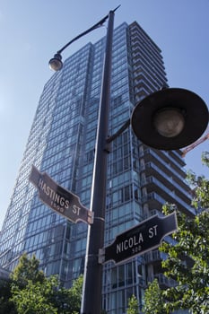 Vancouver, Canada - September 20, 2019 View of crossroad signpost Nicola St. and Hasting St. and the Rental Apartments building Bayview at Coal Harbour in the background photo