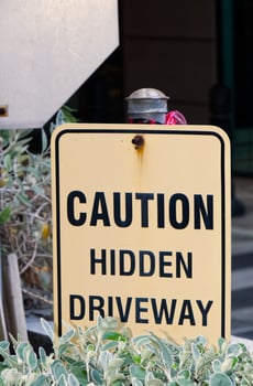 Close up on a Caution Hidden Driveway sign along the driveway of an building parking garage in Vancouver photo