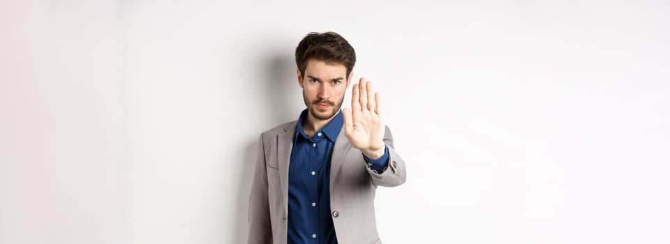 Hold right there. Serious businessman in suit stretch out hand and tell to stop, frowning and look confident, disapprove action, prohibit something bad, standing on white background photo