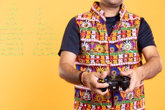 Close up shot of man wearing colorful vest playing videogames using controller, studio background. Gamer holding gamepad, participating in online multiplayer game using console system photo