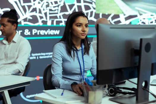 Indian female operator monitoring trucks routes and activity in traffic, working with satellite navigation and CCTV surveillance footage. Helping couriers with gps coordinates for destination. photo