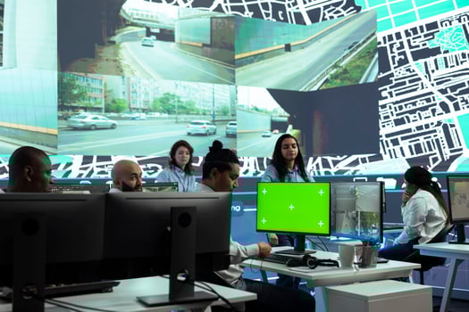 Indian dispatcher examines CCTV security footage and greenscreen, monitoring delivery truck drivers activity in traffic. Young call center operator follows couriers via surveillance system. photo