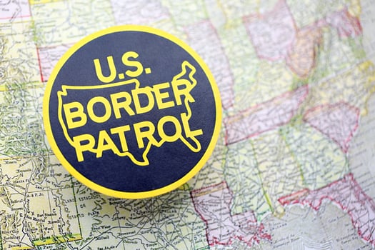 KYIV, UKRAINE - JUNE 26, 2024 U.S. Border Patrol coat of arms on paper map of United States photo
