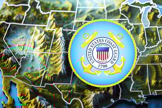 KYIV, UKRAINE - JUNE 26, 2024 United States Coast Guard coat of arms on paper map of United States photo