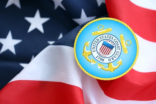 KYIV, UKRAINE - JUNE 26, 2024 United States Coast Guard coat of arms sticker on folded US flag photo