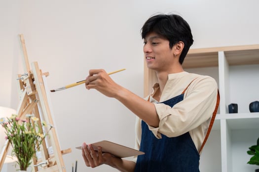Young Artist Painting on Canvas in Modern Studio with Natural Light and Creative Ambiance photo