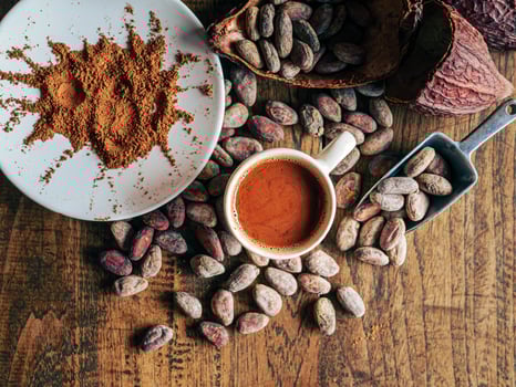 Top view of hot chocolate drink,cocoa drink and natural cocoa powder with brown cocoa beans and dry cacao pod on a vintage wooden table. photo