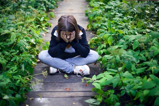 Sad girl sitting in garden photo