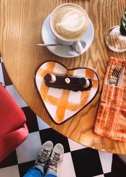 Crop woman at table with dessert and coffee photo