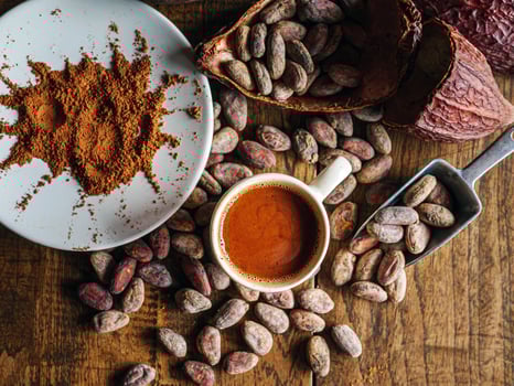 Top view of hot chocolate drink,cocoa drink and natural cocoa powder with brown cocoa beans and dry cacao pod on a vintage wooden table. photo
