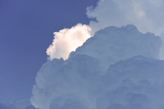 Blue-white cumulus clouds in the rays of the sun. Thunderstorm clouds. photo