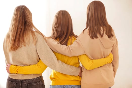 Unrecognizable girlfriends hugging each other photo