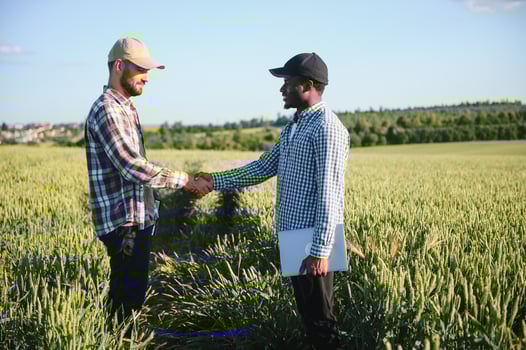 handshake farmer wheat. business partnership agriculture concept. two multiracial farmers shaking hands photo