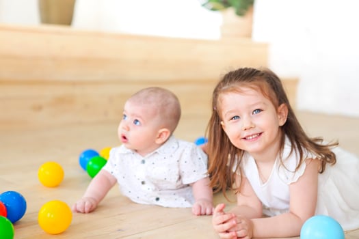 Baby boy and his sister playing with balls. Colorful toys for kids. Kids in play room photo
