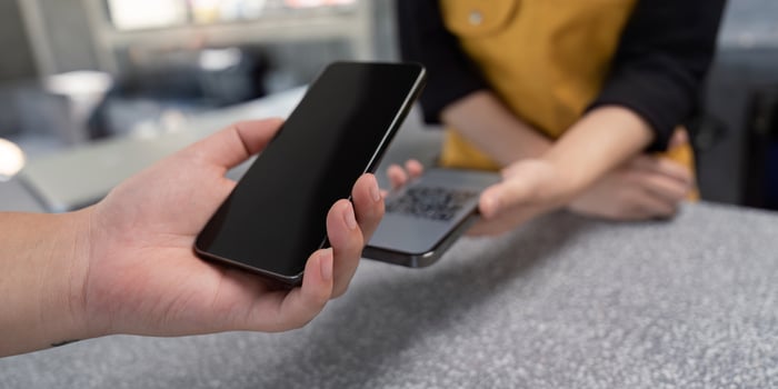 Close up of Hands Using Mobile Phones for Contactless Payment at a Modern Retail Counter photo