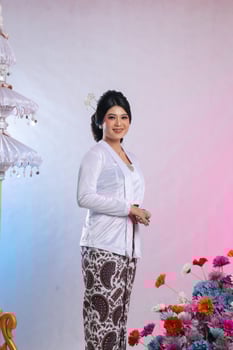 Young indonesia woman standing smiling wearing modern Javanese traditional clothing, white velvet bridal kebaya on white studio background. for advertising content, romance, beauty, fashion photo