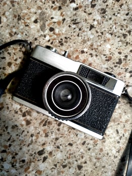 old film camera gear isolated on a granite stone pattern floor background. retro photography vintage. nostalgic vacation historical moment photo