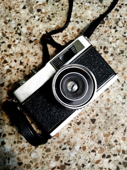 old film camera gear isolated on a granite stone pattern floor background. retro photography vintage. nostalgic vacation historical moment photo