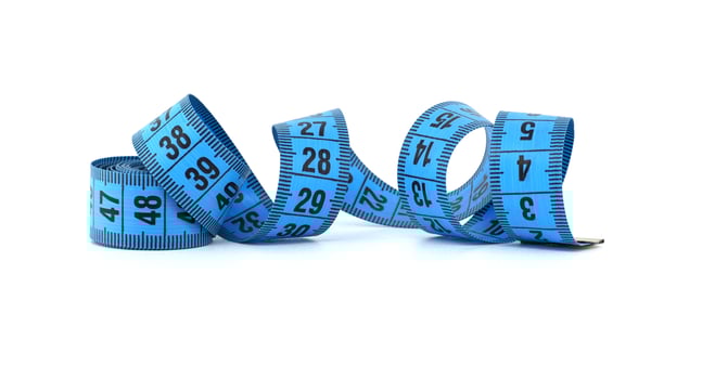 Blue measuring tape curled on white background representing fitness and precision photo