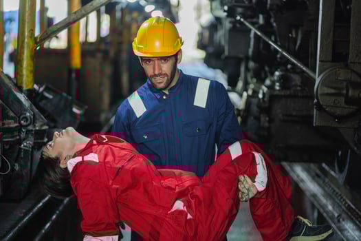man in a yellow helmet is holding a woman in a red jumpsuit photo