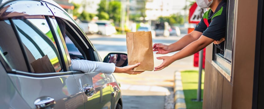 man is handing a bag to a woman at a restaurant photo