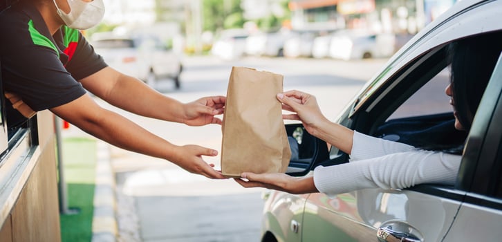man is handing a bag to a woman at a restaurant photo
