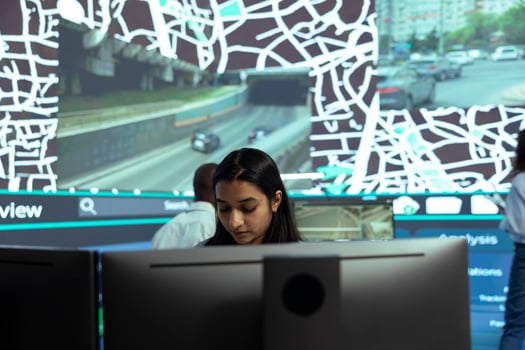 Indian woman locating delivery trucks in traffic via satellite map with gps coordinates, monitoring route and destination to ensure order shipment. Agency employee uses public surveillance system. photo