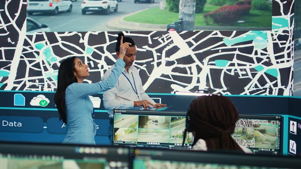 Indian supervisors examining traffic routes on satellite map, gathering data on surveillance CCTV system to ensure express delivery. Employees tracing and locating trucks with gps network. Camera B. photo