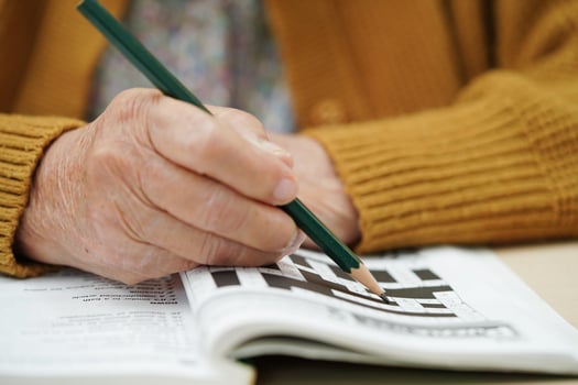 elderly woman playing sudoku puzzle game. photo