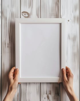 Hands Placing Blank Photo Frames on Wall for Mockup