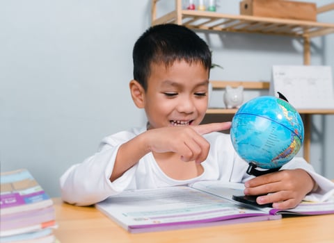Asian boy looking and point your finger at globe find the location of countries in the world, Concept for research global warming, global network, SEO search engine, Save the Earth, Kid Education. photo