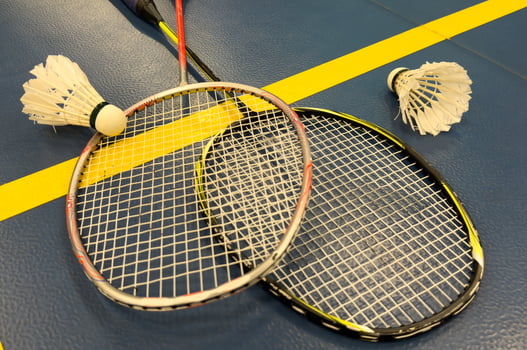 Shuttlecock on badminton racquet on floor. photo