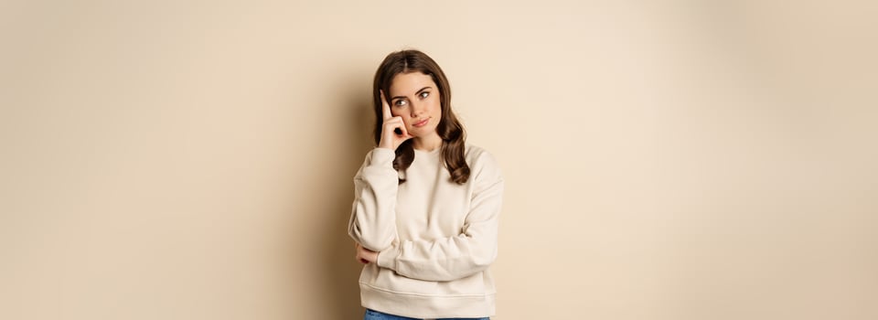 Annoyed woman, roll eyes and looking unamused, bothered and bored, standing over beige background photo