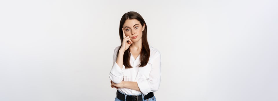 Unamused, bored brunette woman looking gloomy and sad, sighing, standing reluctant over white background photo