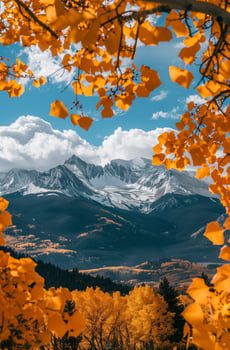 Sunny autumn landscape with snowy mountains surrounded by forests photo
