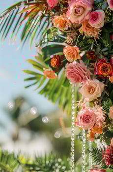 Beautiful festive arch decoration of roses, greenery and tropical leaves with crystal bead garlands photo