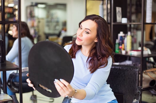 Young beautiful long haired woman smiling to the mirror photo