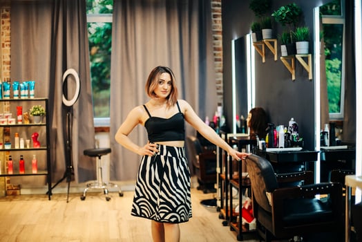 Professional female hairdresser standing in modern beauty salon interior photo