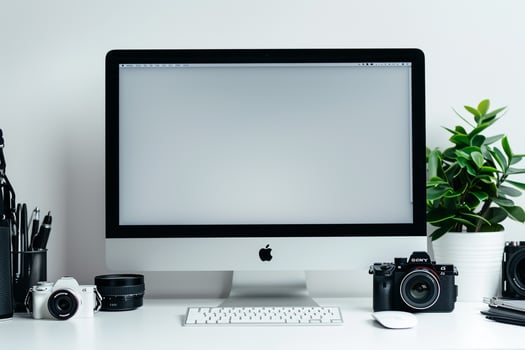 Computer Mockup Background on a white desk with graphy gear and tech gadgets arranged Background photo