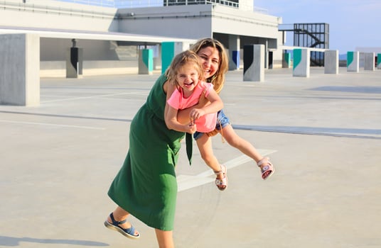 Happy mother with her little baby girl at urban background photo