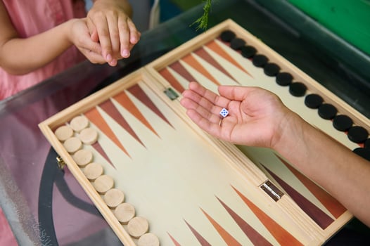 Family quality time playing backgammon board game at home photo