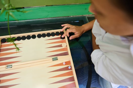 Top view of a person playing a game of Backgammon on a wooden board photo