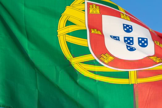 Close-up photography of national flag of Portuguese Republic on blue sky background photo