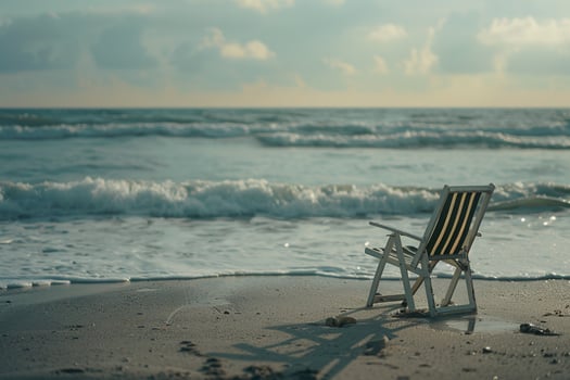 Solitary beach chair facing the ocean with gentle waves evoking a peaceful and scenic coastalbackground photo
